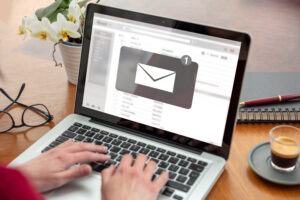 Image featuring a person typing, with a laptop screen displaying an envelope icon. This image is used to illustrate an email marketing blog.